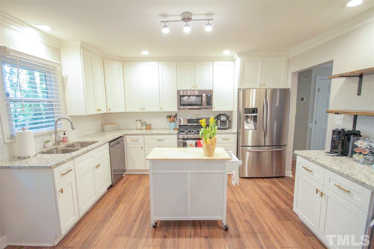 8212 Hambledon Court Raleigh, NC 27615 - Photo 3 of 28 a kitchen with stainless steel appliances a refrigerator sink and cabinets