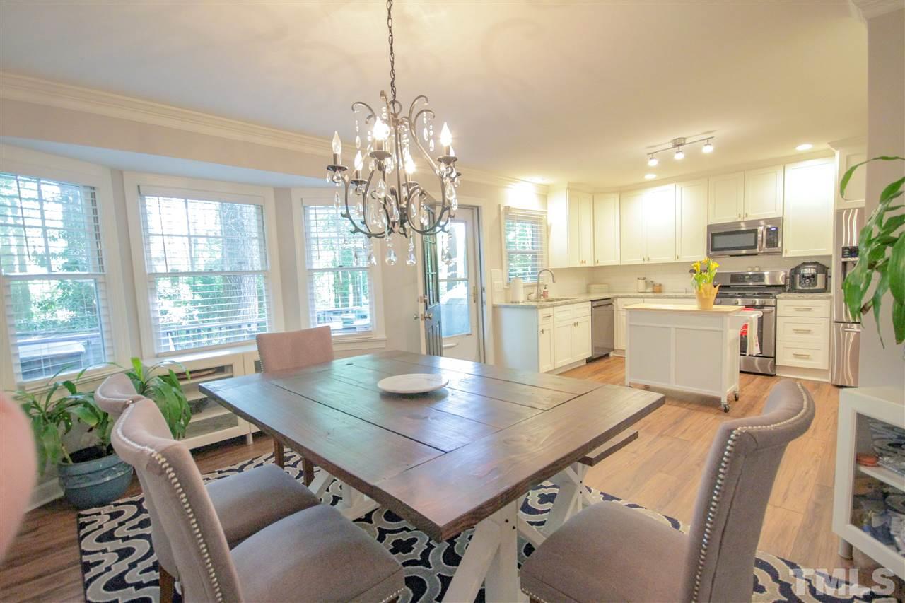 8212 Hambledon Court Raleigh, NC 27615 - Photo 4 of 28 a view of a dining room and livingroom with furniture wooden floor a chandelier