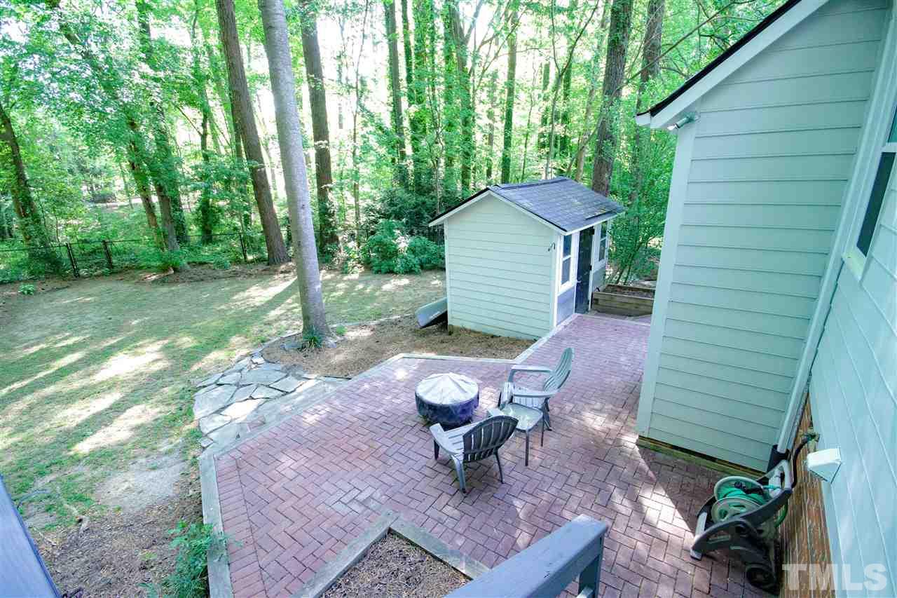 8212 Hambledon Court Raleigh, NC 27615 - Photo 5 of 28 a view of a backyard with table and chairs potted plants and large tree