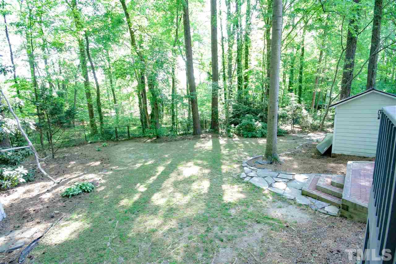8212 Hambledon Court Raleigh, NC 27615 - Photo 6 of 28 a backyard of a house with large trees and plants