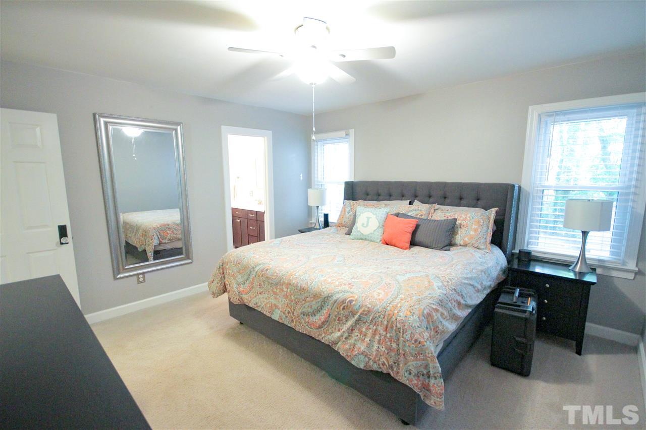 8212 Hambledon Court Raleigh, NC 27615 - Photo 9 of 28 a bedroom with a large bed and a chandelier