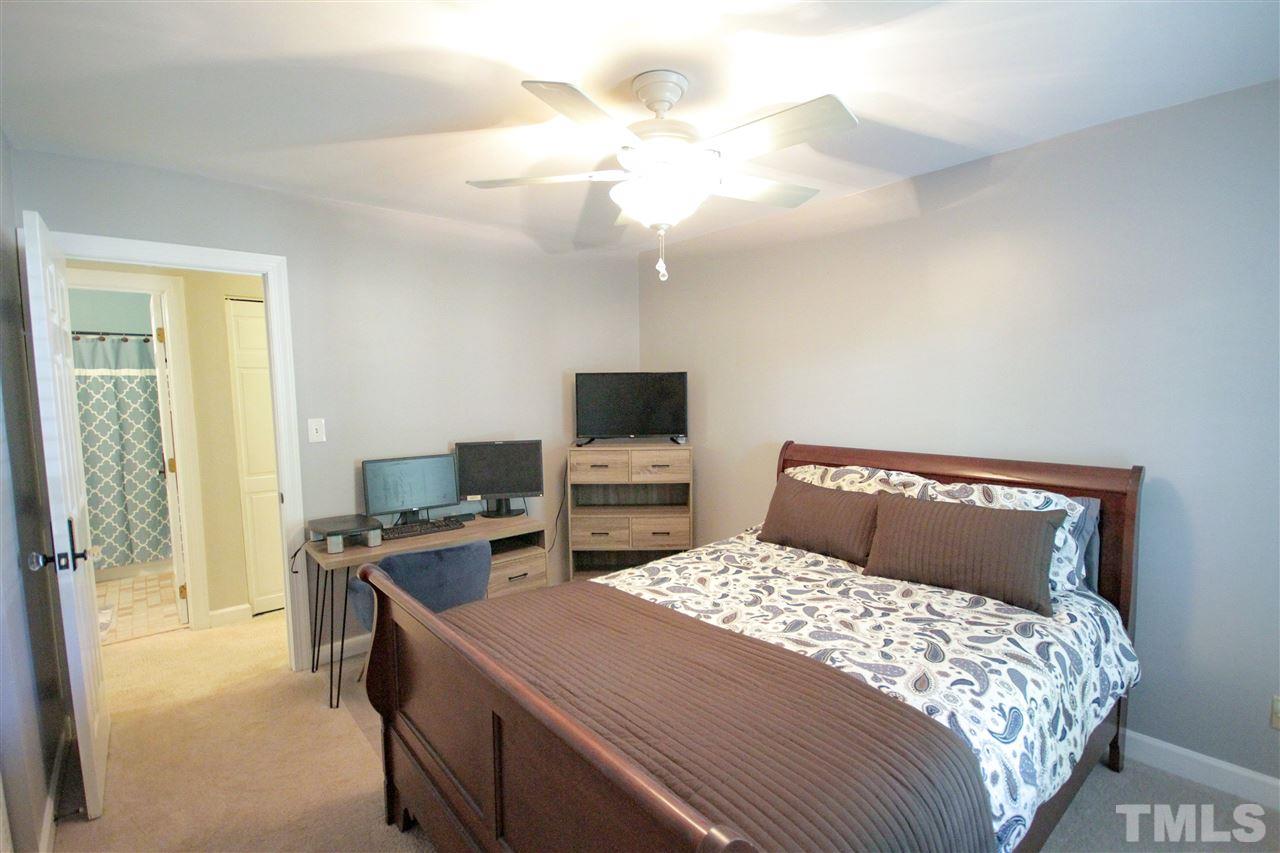 8212 Hambledon Court Raleigh, NC 27615 - Photo 10 of 28 a bedroom with a large bed and a flat tv screen on a dresser