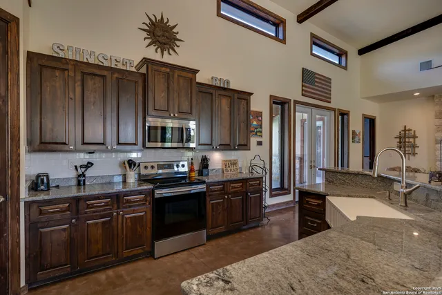 a kitchen with stainless steel appliances granite countertop a sink stove and refrigerator