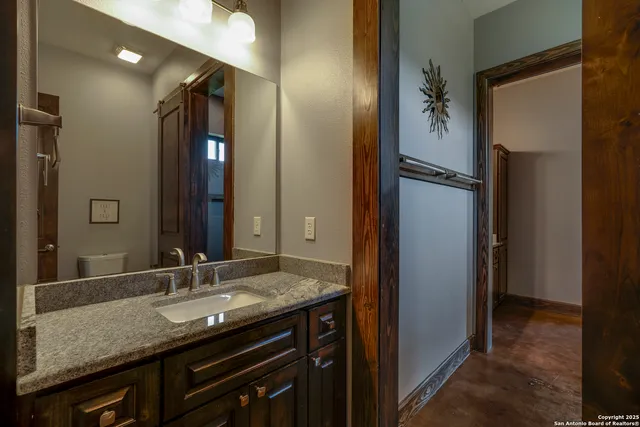 a bathroom with a granite countertop sink and a mirror