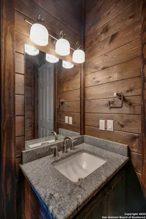 a kitchen with a granite countertop sink and a mirror