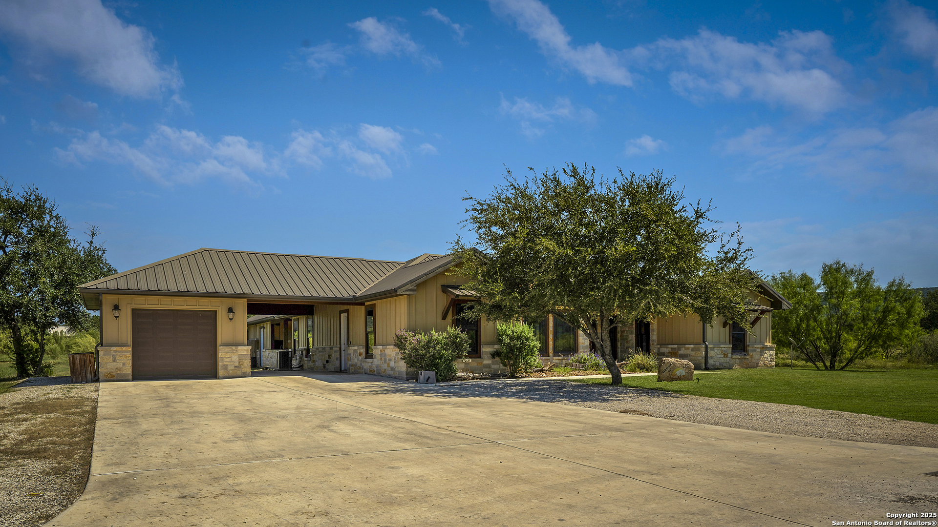 1185 Mountain Vly Drive Concan, TX 78838 - Photo 2 of 27 a front view of a house with a yard and garage