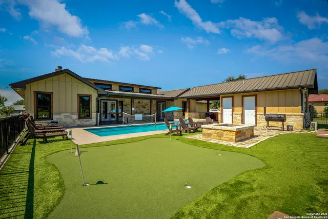 a view of a house with swimming pool and sitting area