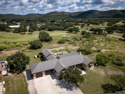 aerial view of a house with a yard and lake view