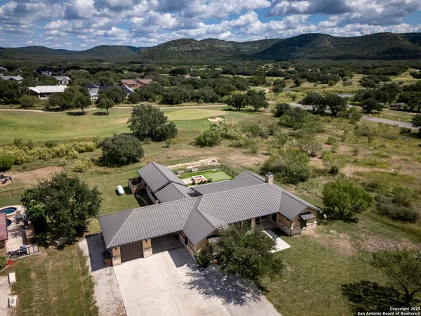 aerial view of a house with a yard and lake view