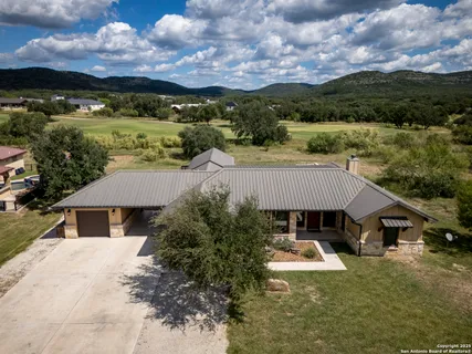 an aerial view of house with yard and mountain view in back