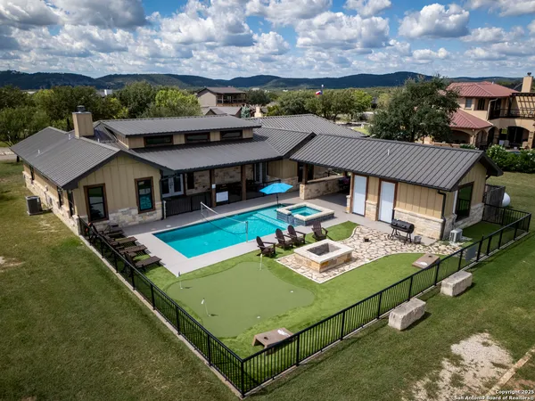 an aerial view of a house with swimming pool and a yard