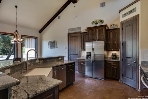 a kitchen with stainless steel appliances granite countertop a sink refrigerator and cabinets