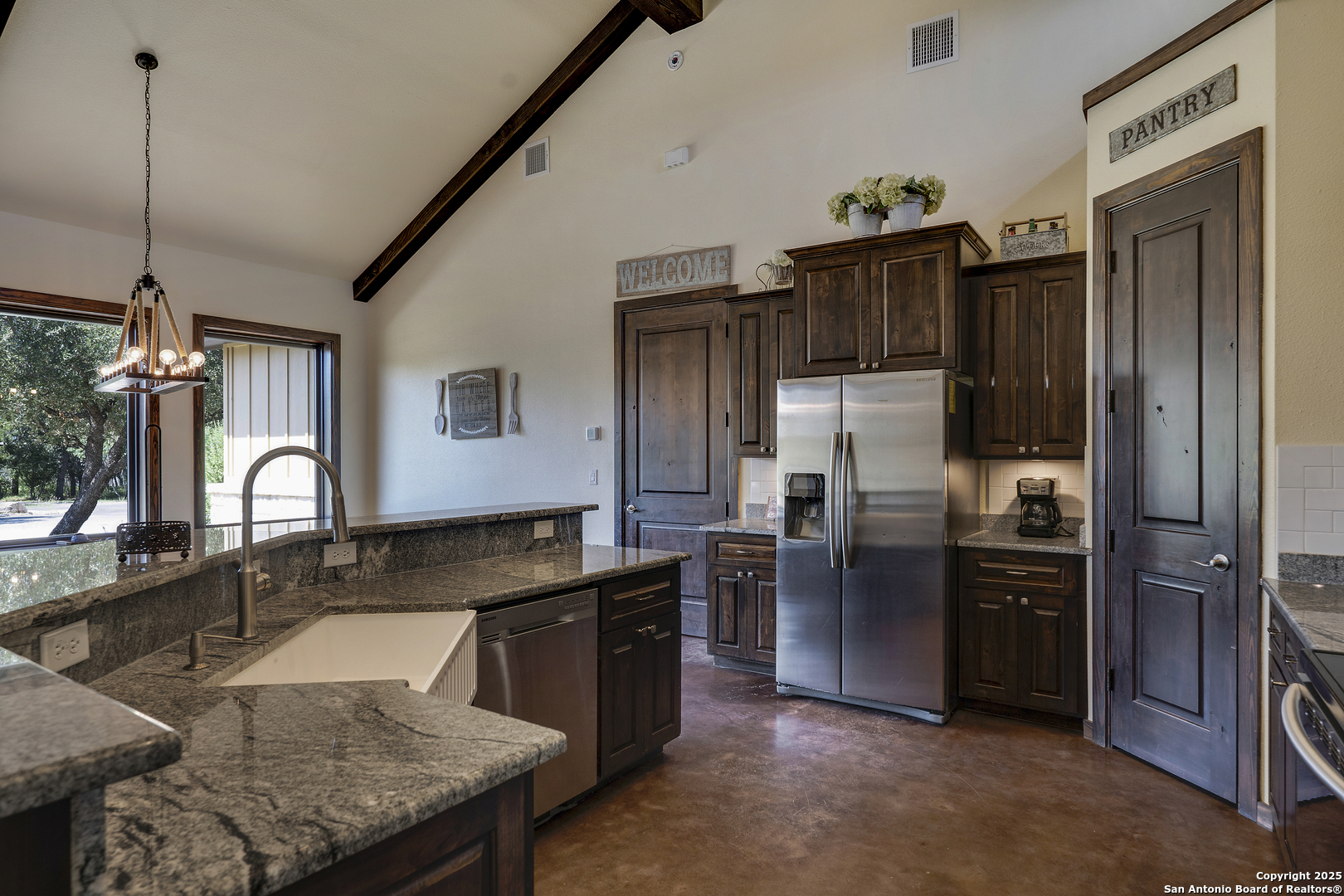 1185 Mountain Vly Drive Concan, TX 78838 - Photo 10 of 27 a kitchen with stainless steel appliances granite countertop a sink refrigerator and cabinets