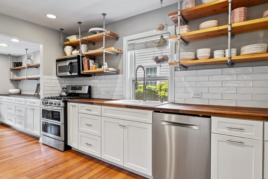 618 Willow Road Winnetka, IL 60093 - Photo 15 of 27 a kitchen with stainless steel appliances granite countertop a sink and cabinets