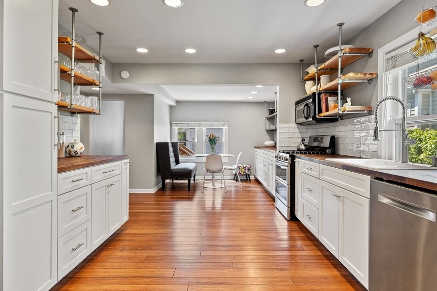 618 Willow Road Winnetka, IL 60093 - Photo 16 of 27 a large white kitchen with lots of counter space wooden floor and stainless steel appliances