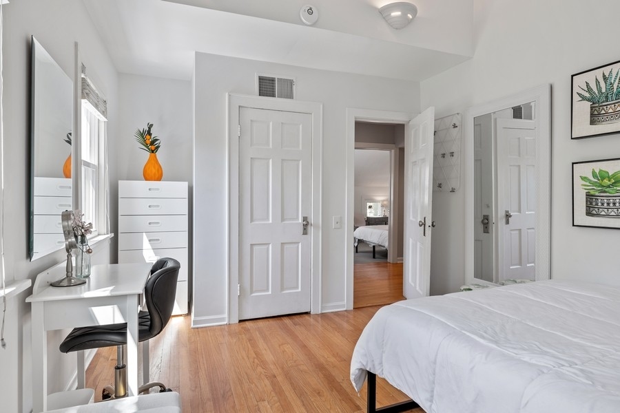 618 Willow Road Winnetka, IL 60093 - Photo 18 of 27 a bedroom with a bed and a dresser with wooden floor