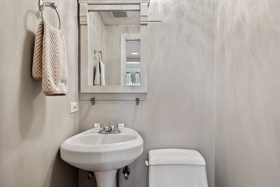618 Willow Road Winnetka, IL 60093 - Photo 10 of 27 a bathroom with a sink a toilet and a mirror