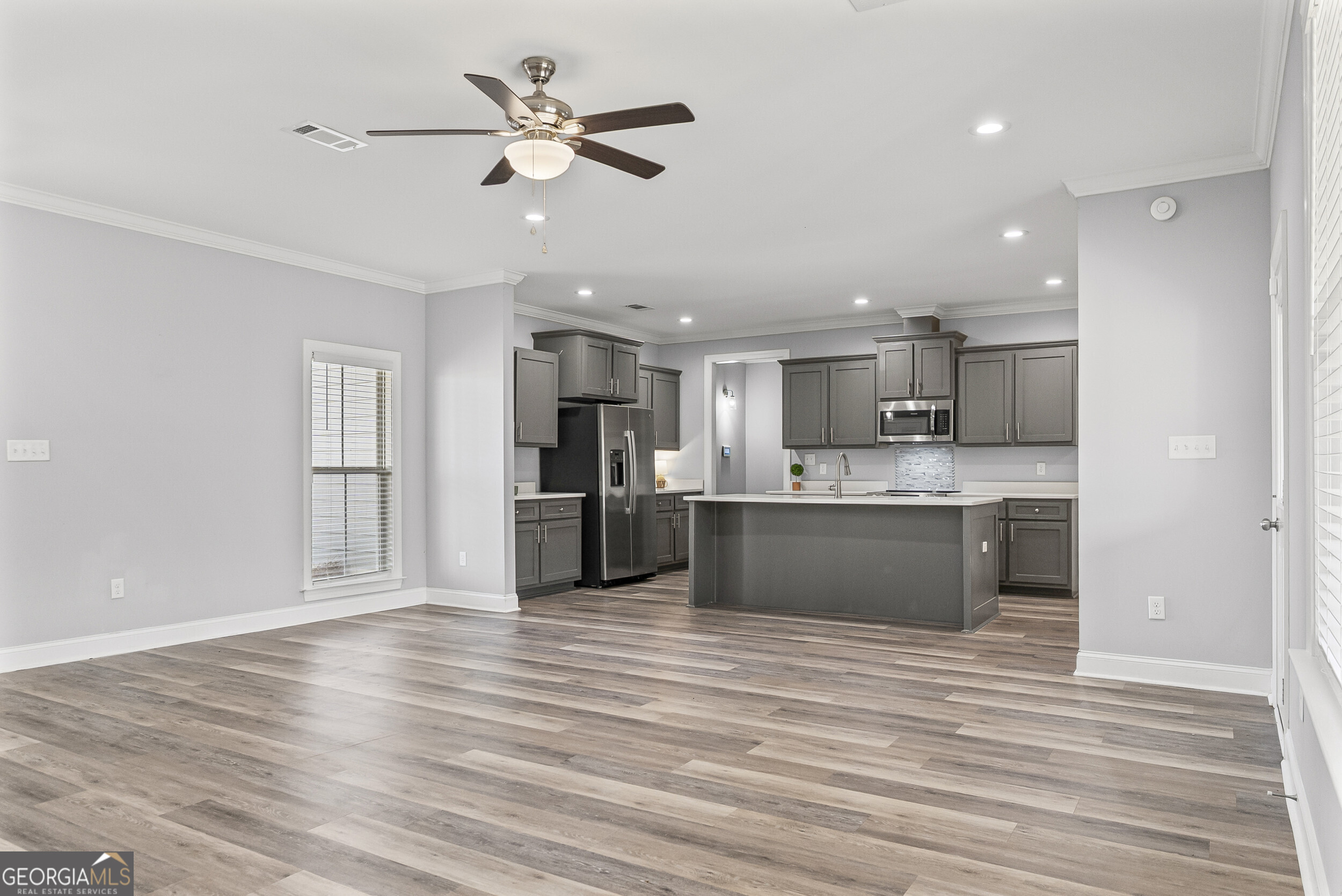 144 Scarlet Way Leesburg, GA 31763 - Photo 10 of 30 a large kitchen with stainless steel appliances kitchen island a large counter top and stove top oven