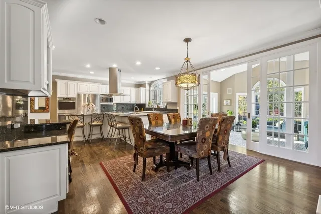 a dining room with furniture a chandelier and wooden floor