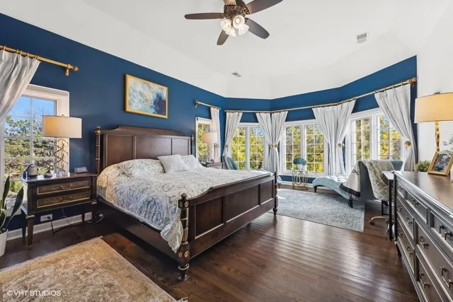 a bathroom with a double vanity sink a mirror a window and a bathtub