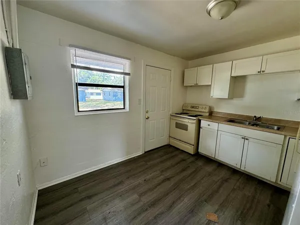 a kitchen with wooden floor and a sink