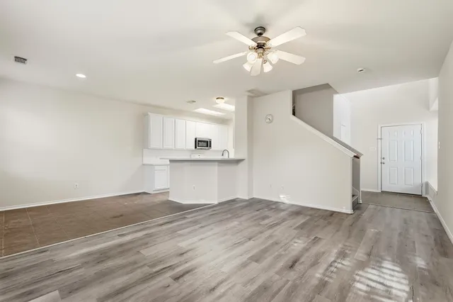 a view of a kitchen with wooden floor and a ceiling fan