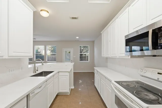 a kitchen that has a sink and a stove in it
