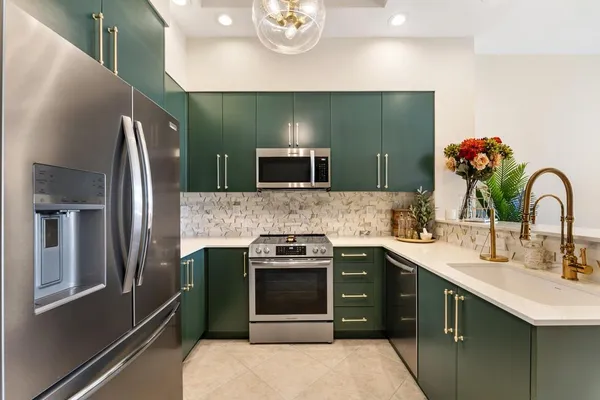 a kitchen with stainless steel appliances granite countertop a refrigerator and a stove