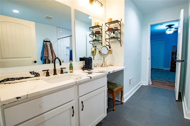 a bathroom with a granite countertop sink a toilet and shower