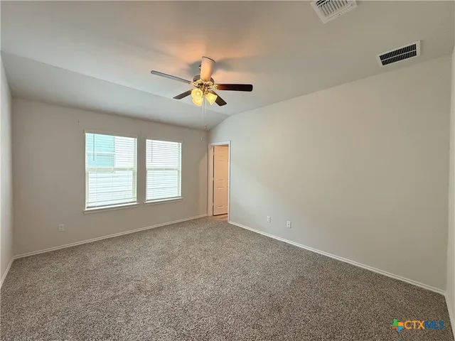 a view of room with a ceiling fan and a window