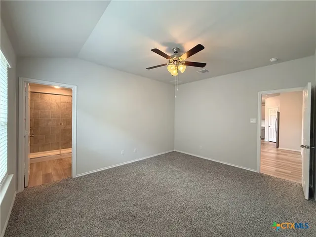 an empty room and chandelier fan