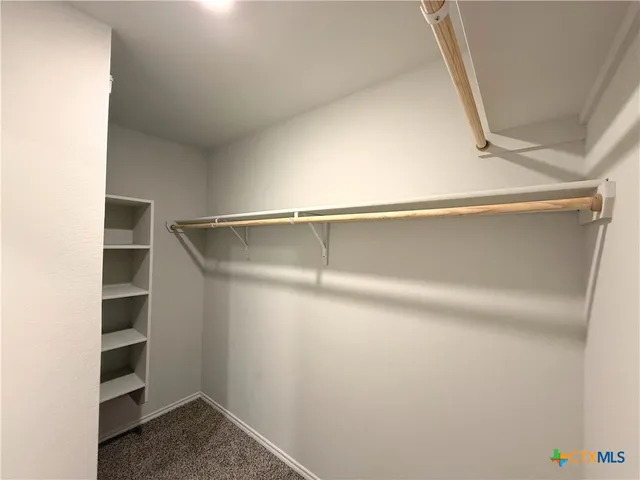 a view of walk in closet with empty racks