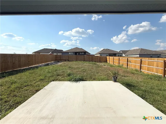 a view of a yard with an house in the background