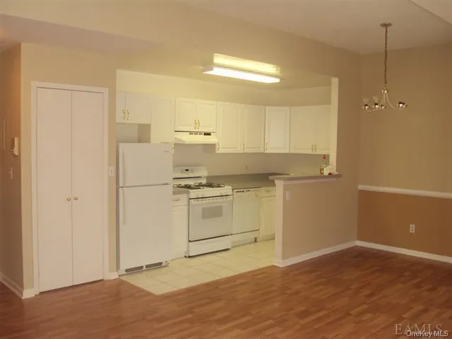 a kitchen with a refrigerator and white cabinets