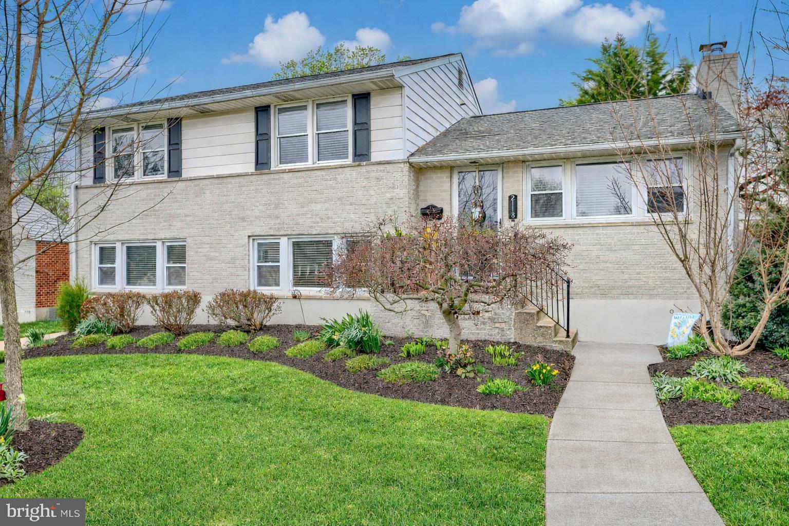 a front view of a house with a garden and plants
