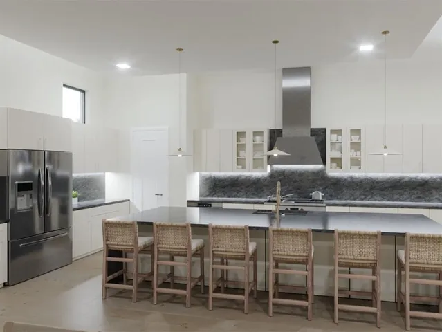a kitchen with granite countertop kitchen island stainless steel appliances a sink and a refrigerator