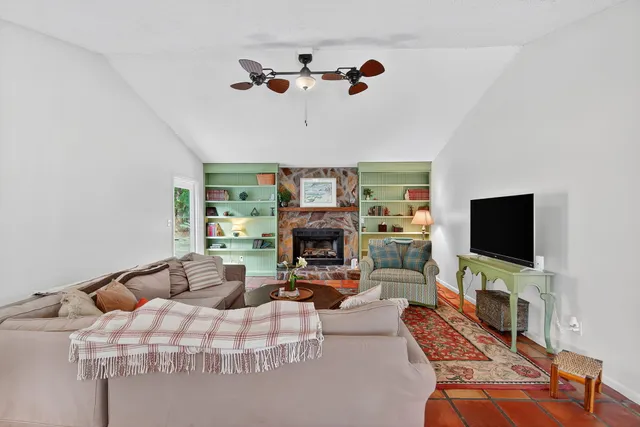 a living room with furniture a flat screen tv and a fireplace