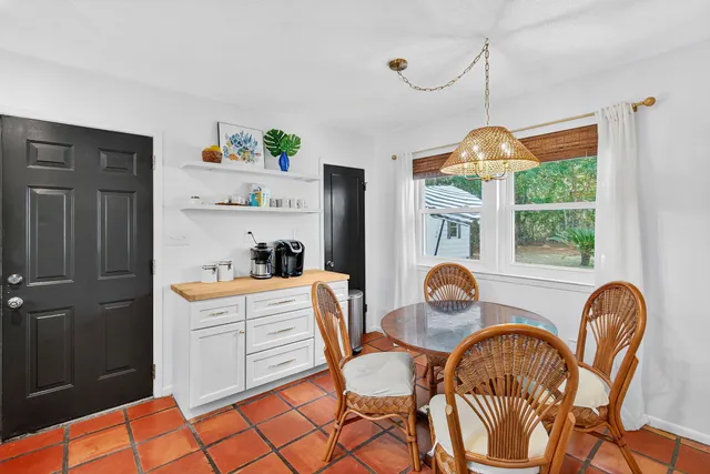 a dining room with furniture a chandelier and window