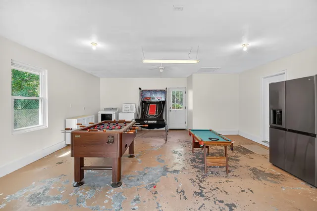 a living room with furniture a dining table and a refrigerator