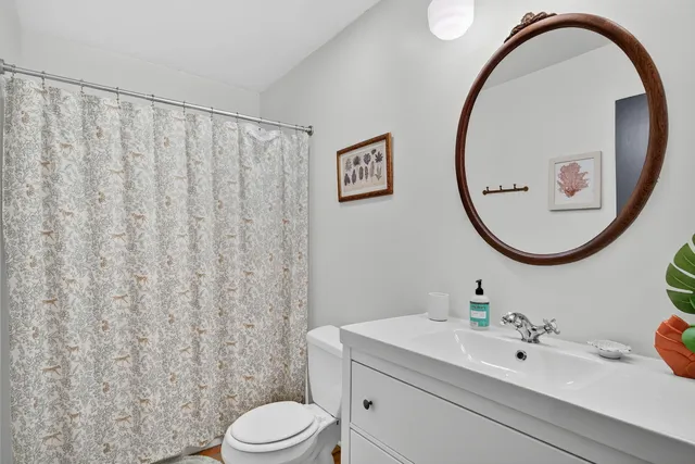 a bathroom with a sink a mirror a toilet and a mirror