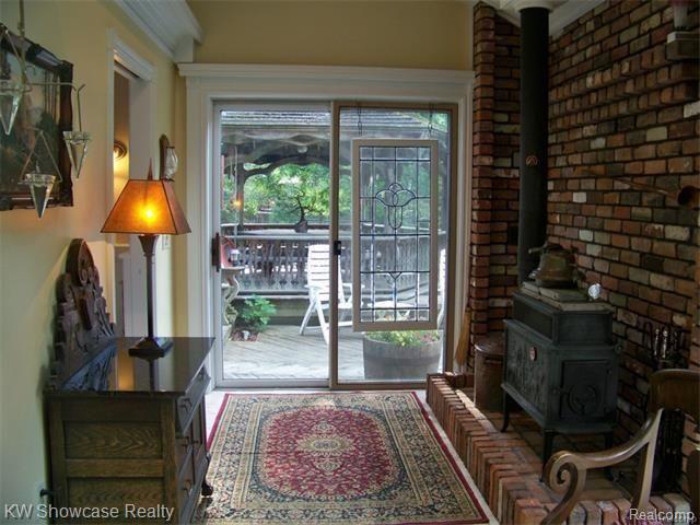 47200 West 11 Mile Road Novi, MI 48374 - Photo 25 of 62 Orig. Brick Hearth, Wood Burner, Door Wall to Deck. Could also be an Office space with great views, Gazebo & Gardens! Glass Alcove Opposite. Charm everywhere you look in this home!