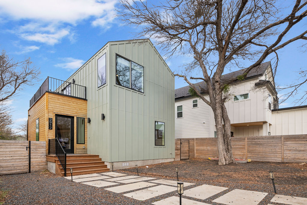 a front view of a house with a tree