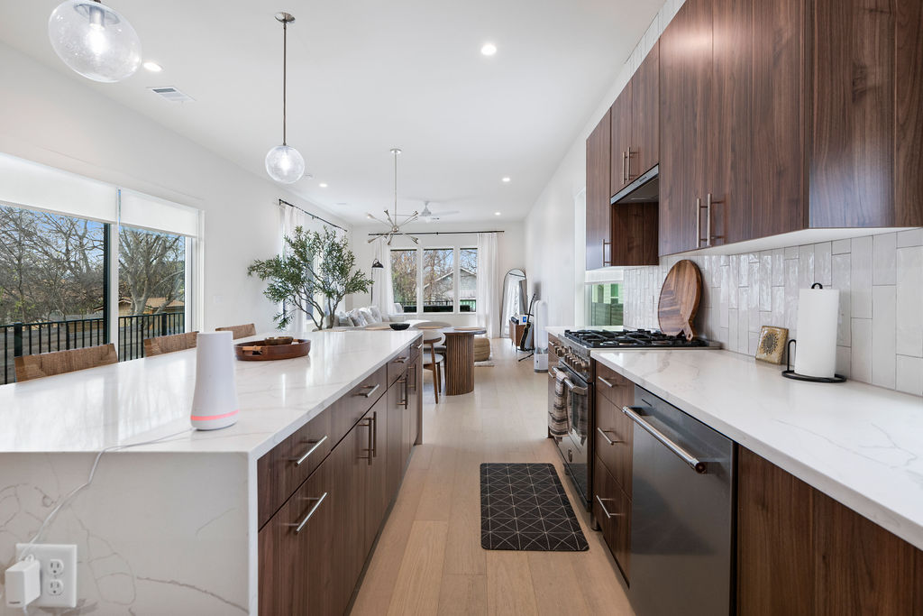 2912 East 13th Street Austin, TX 78702 - Photo 11 of 40 a kitchen with stainless steel appliances a sink a counter top space cabinets and a wooden floor