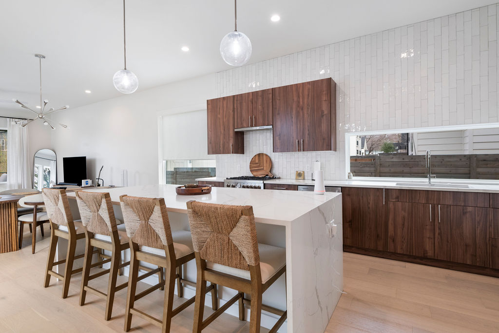2912 East 13th Street Austin, TX 78702 - Photo 9 of 40 a kitchen with stainless steel appliances kitchen island granite countertop a sink a microwave a center island and cabinets