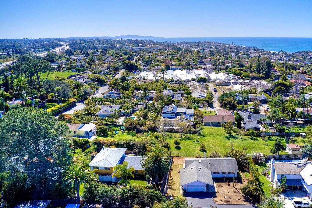 an aerial view of residential houses with outdoor space and trees
