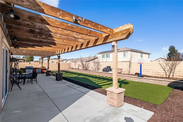 a patio with a table and chairs and potted plants