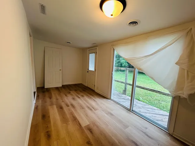 a view of a room with wooden floor and window