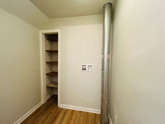 a view of walk in closet with wooden floor