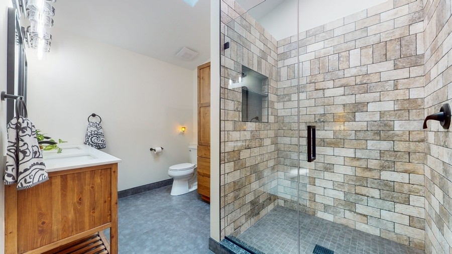 43375 Hunt Club Road Zion, IL 60099 - Photo 12 of 56 a bathroom with a granite countertop shower a toilet and a sink