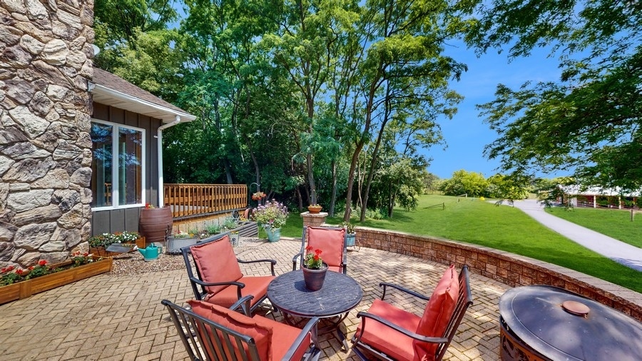 43375 Hunt Club Road Zion, IL 60099 - Photo 21 of 56 a backyard of a house with table and chairs potted plants and large tree